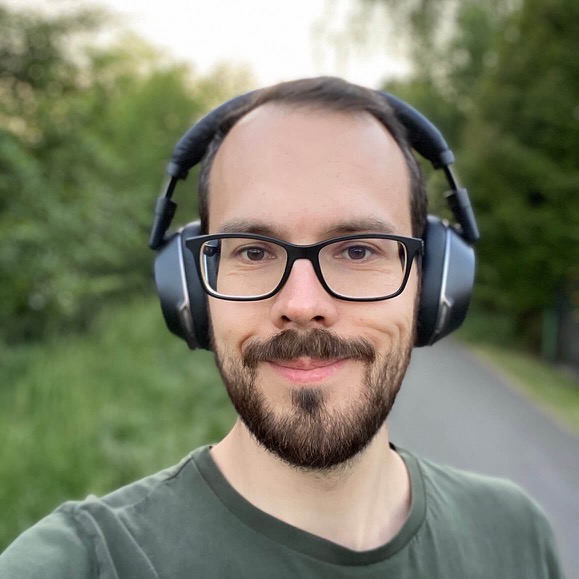 Profilansicht männliche Person mit Over Ear Kopfhörern. Die abgebildete Person ist Paul-Christian Ablaß.
